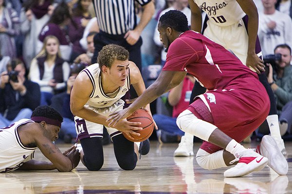 Texas A&M forward D.J. Hogg (1) attempts to hold on to a fumbled pass while Arkansas forward Arlando Cook (5) defends during an NCAA college basketball game Tuesday, Jan. 17, 2017 at Reed Arena in College Station, Texas. (Timothy Hurst/College Station Eagle via AP)

