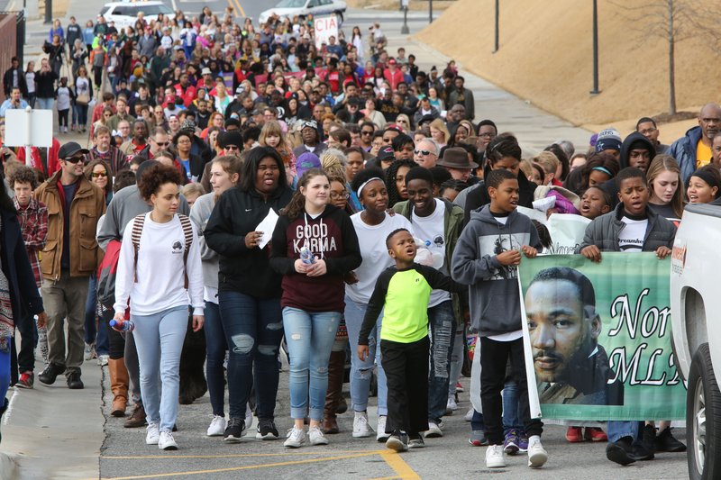 Marchers participate Monday in the annual Martin Luther King Jr. Freedom March to the campus of the University of Arkansas in Fayetteville. Participants in the march began near the corner of Razorback Road and Martin Luther King Jr. Boulevard and marched, sang and chanted to the Arkansas Union for the Martin Luther King Jr. Vigil. The event was co-sponsored by the University of Arkansas Associated Student Government, the Black Student Association and the Northwest Arkansas Martin Luther King Jr. Council.