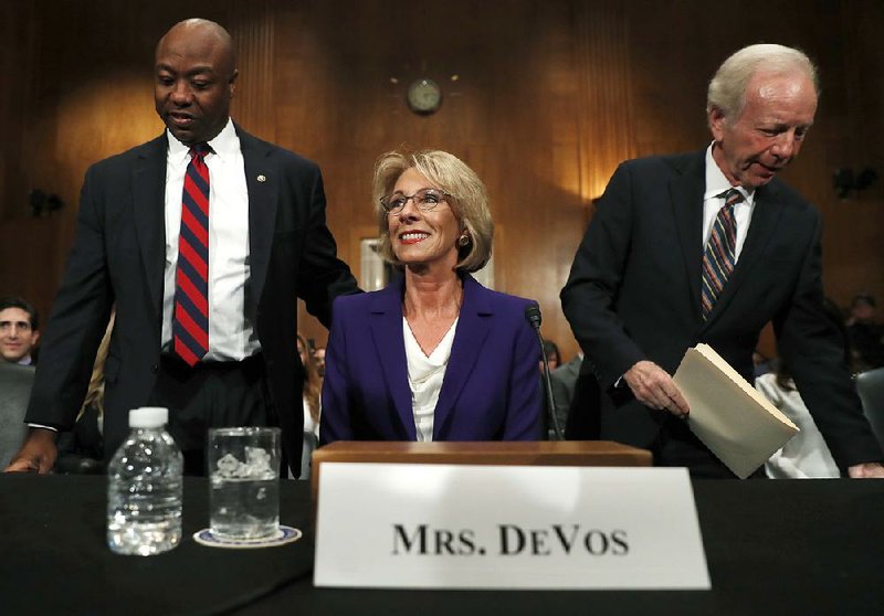 Betsy DeVos, Donald Trump’s choice to lead the Education Department, arrives for a Senate hearing Tuesday with Sen. Tim Scott (left), R-S.C., and former Sen. Joe Lieberman of Connecticut. DeVos vowed to be “a strong advocate for great public schools” while supporting access to “a high-quality alternative.”