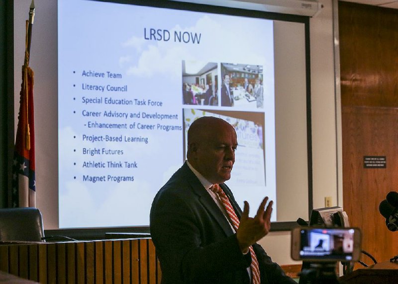 Little Rock School District Superintendent Mike Poore gives a presentation at a news conference Tuesday on his proposed cuts for the district’s budget and changes for facilities.