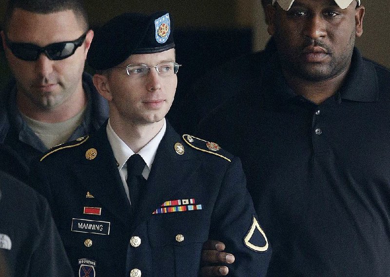 Army Pfc. Bradley Manning is escorted on Aug. 20, 2013, to a security vehicle outside a courthouse at Fort Meade, Md., after a hearing in his court-martial in this file photo. Manning, a transgender woman now known as Chelsea, had her sentence commuted Tuesday by President Barack Obama and will leave prison on May 17.