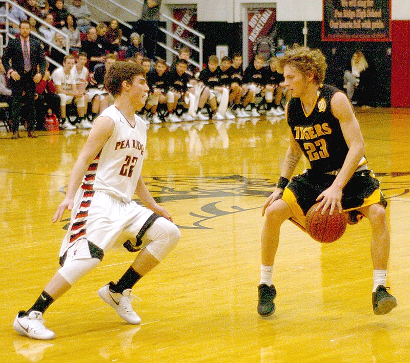 Photo by Mark Humphrey/Enterprise-Leader/Making a move. Prairie Grove senior Taylor Moore utilizes a crossover dribble while Pea Ridge junior Hayden Holtgrewe defends. The Tigers lost their second conference game of the season, 74-43, at Pea Ridge Jan. 10.