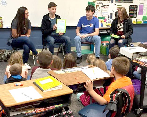 Submitted Photo Madi Powlowski, Mason West, Kevin German and Cali Stevens, pre-AP English II students at Gentry High School, took turns reading books they wrote to first-grade students on Jan. 11.