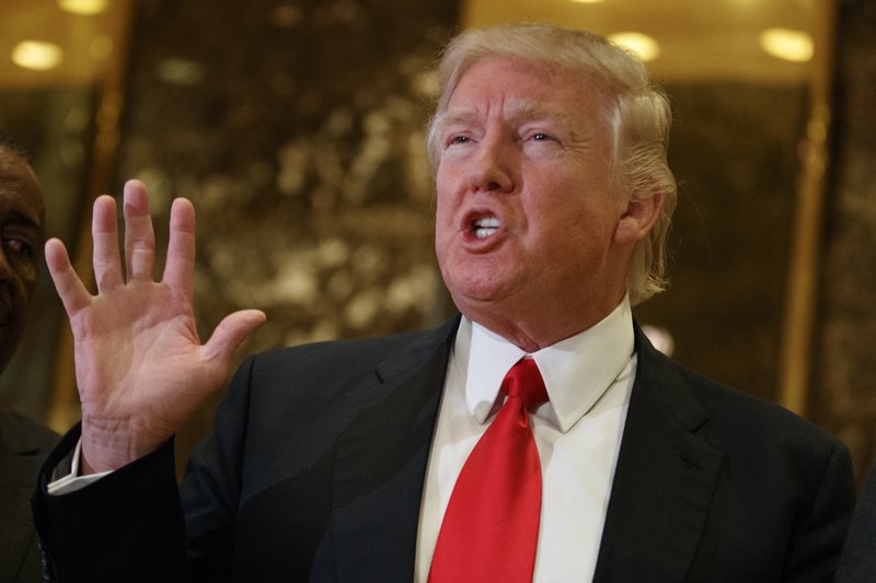 In this Jan. 13, 2017 file photo, President-elect Donald Trump speaks with reporters in the lobby of Trump Tower in New York. 