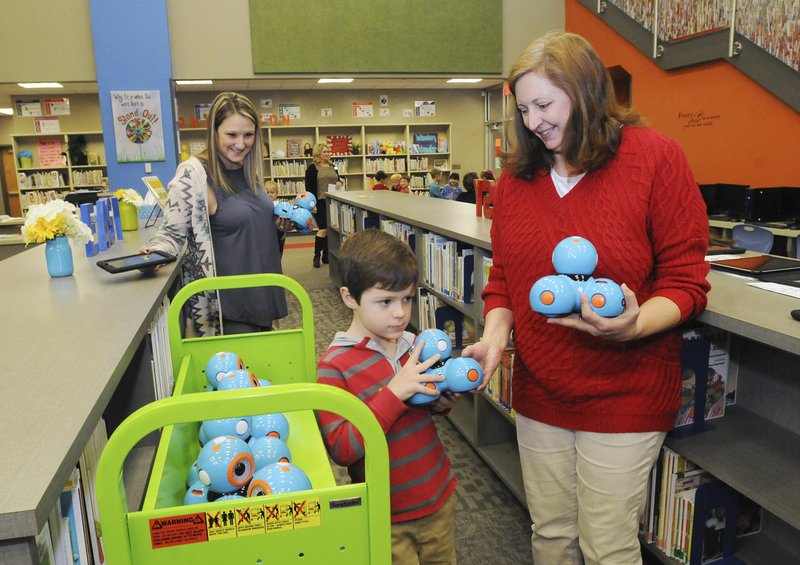 NWA Democrat-Gazette/FLIP PUTTHOFF Allison Floyd (left), librarian at Janie Darr Elementary School in Rogers, and library aide Julie Sebastion collect robots and tablet computers from first-graders Tuesday after a lesson. The school is the newest in the Rogers School District and in southwest Rogers, the fastest growing area in the district.