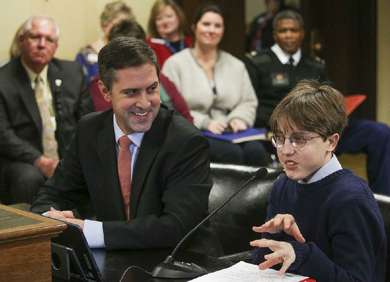 Mason Cyprus Oury, a Fayetteville High School senior, accompanied by Rep. Greg Leding, D-Fayetteville, gives a presentation Wednesday to a House panel on why the Arkansaurus fridayi should become the state dinosaur. Leding submitted a bill calling for the designation after Oury contacted him with the idea. Oury told the panel that Oklahoma, Texas and Missouri have state dinosaurs. Asked to describe the Arkansaurus, discovered in Lockesburg in 1972 by Joe B. Friday, Oury said it resembled an ostrich. The motion to move the bill to the full House passed unanimously.