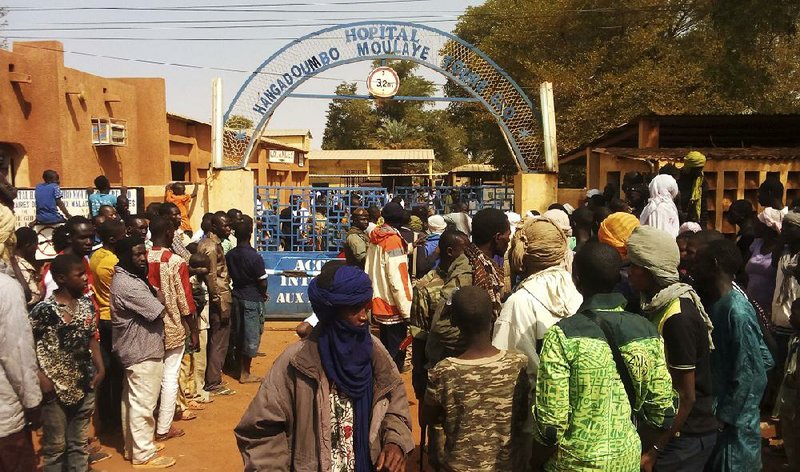 People gather outside a hospital where the injured were taken after a suicide attack Wednesday at a military base in Gao, Mali.