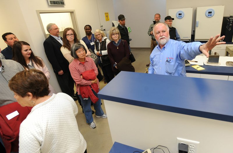 NWA Democrat-Gazette/ANDY SHUPE Gordon Whitbeck (right), president and microbiologist of Whitbeck Labs in Springdale, leads a tour Wednesday at the new office and laboratory for the longtime poultry testing company in Springdale during a grand opening.