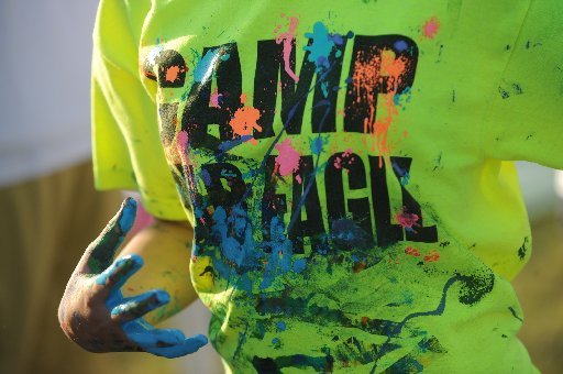 A student runs in a paint-covered T-shirt Tuesday, May 1, 2012, while taking part in a paint war at the Jones Center in Springdale during a year-end party and celebration for Camp War Eagle 365, a school-year-long program organized by the camp for middle and high school students ages 7-17.