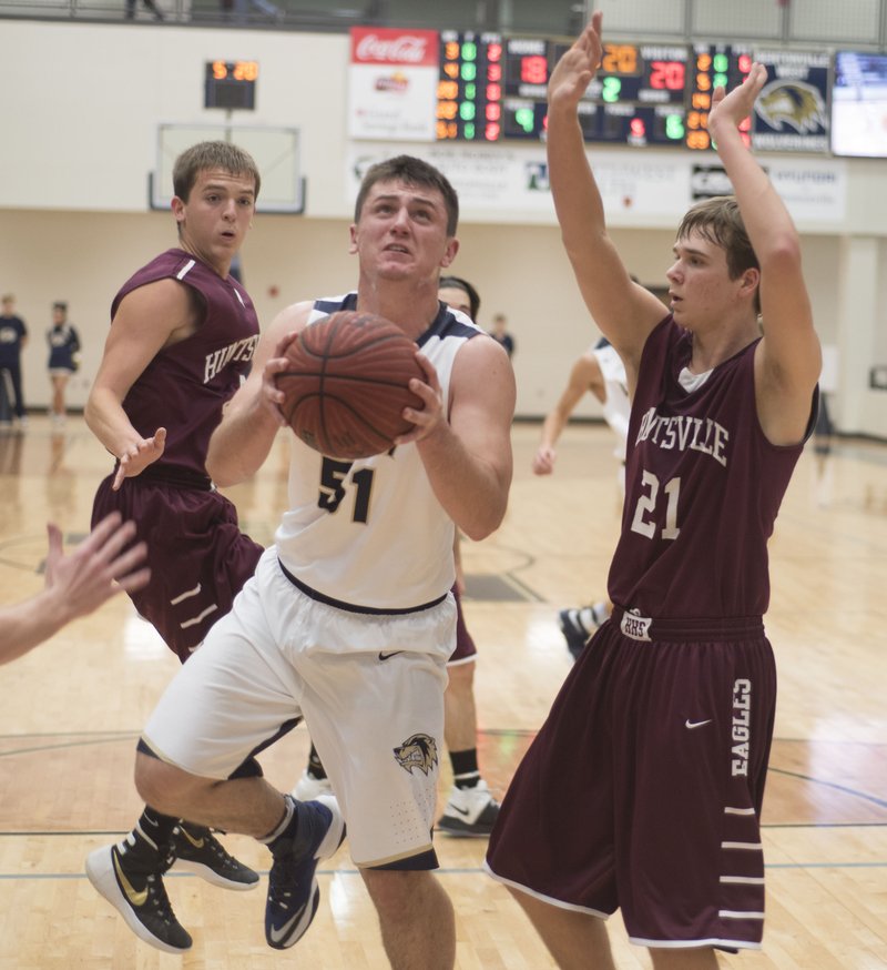 Bentonville West's Levi Rutherford (51) eyes the basket while Huntsville's Aaron Scott defends Dec. 6, 2016, at Wolverine Arena in Centerton.