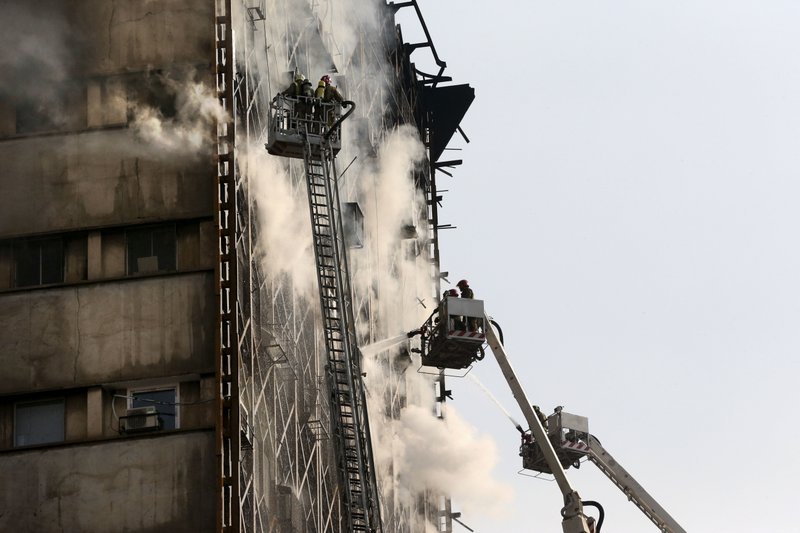 Iranian firefighters work to extinguish fire of the Plasco building in central Tehran, Iran, Thursday, Jan. 19, 2017. A high-rise building in Tehran engulfed by a fire collapsed on Thursday as scores of firefighters battled the blaze. (AP Photo/Vahid Salemi)