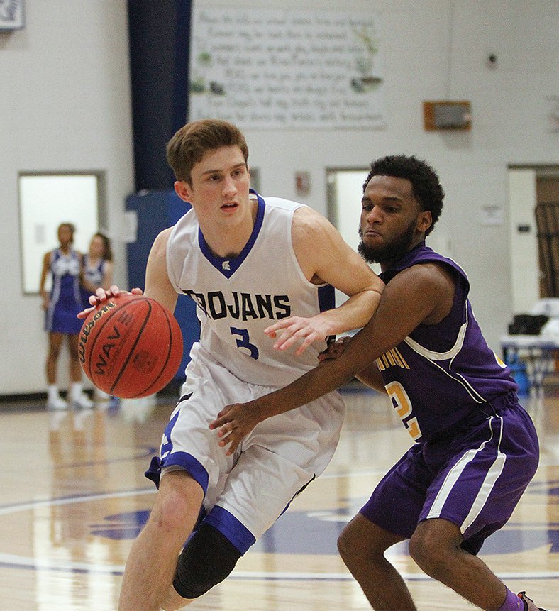 Terrance Armstard/News-Times Parkers Chapel's Bryce Coke drives the ball against the defense applied by Sparkman's Darius Pigg. The Trojans beat the Raiders 73-43 Friday in Parkers Chapel.