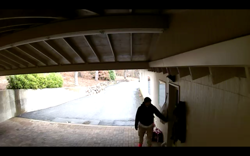 In a still from a security camera video, an unknown man tries the door of a house in the 9000 block of Pinnacle Valley Road. 