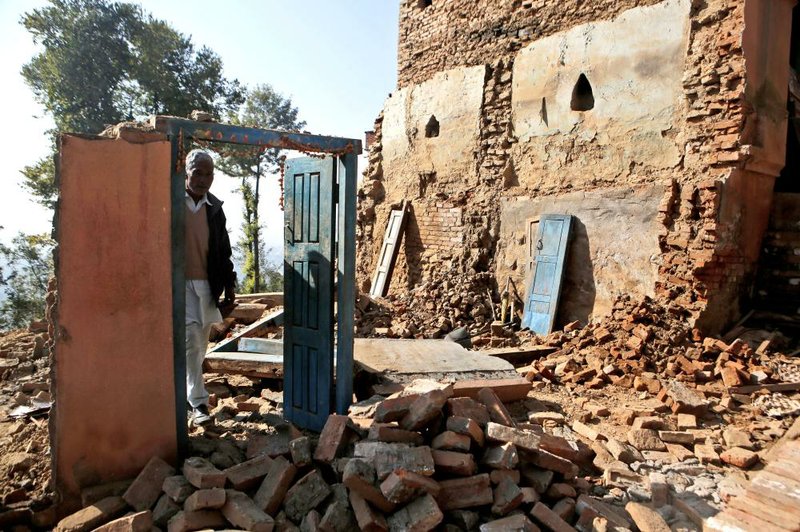 Chandra Lal Bhadal, a Hindu priest, stands in the debris of his house in Changu Village in Nepal that was destroyed in a magnitude-7.8 earthquake in 2015. 
