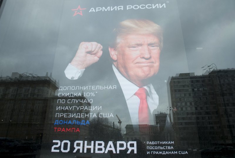 The U.S. Embassy building is reflected in a window of a Russian military outerwear shop "Armia Rossii" (Russian Army) displaying a poster of Donald Trump, in downtown Moscow, Russia, Friday, Jan. 20, 2017, hours ahead of Donald Trump being sworn in as president of the United States, The poster reads: "10 percent discount to the embassy employees and US citizens on the Inauguration Day". 
