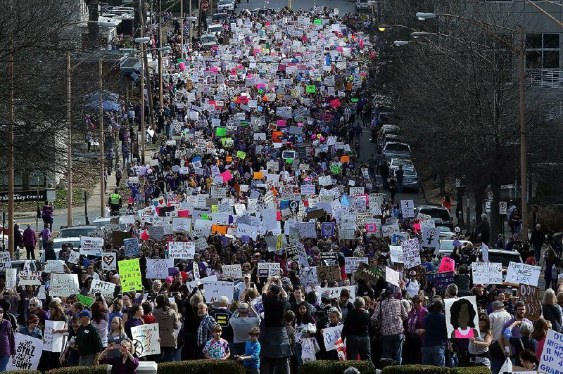 Participants in the Women’s March for Arkansas walk west Saturday along Capitol Avenue in Little Rock toward the state Capitol.