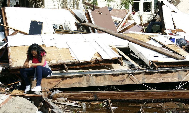 A woman grieves Saturday while sitting on the slab of her destroyed home in Hattiesburg, Miss. The mayor reported “significant injuries” and structural damage around the city.