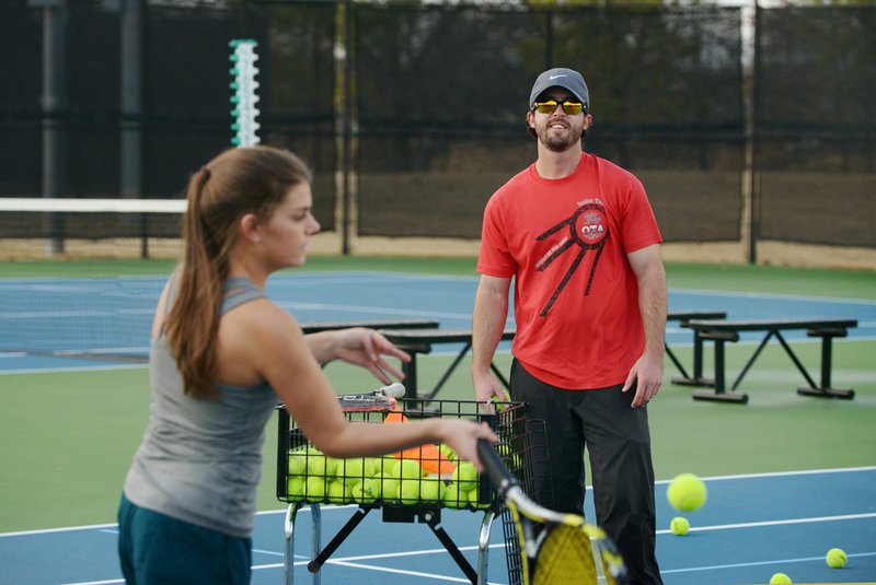 Beau Basham (right) with Bentonville Parks and Recreation gives Sam Keiser of Bentonville a tennis lesson Thursday at Memorial Park in Bentonville. The park’s tennis courts were built with money from a $110 million bond measure approved by voters in 2007. The bond money could be exhausted as early as 2020, said Mayor Bob McCaslin. “That would be a reasonable time to start looking at alternative funding sources,” he said.