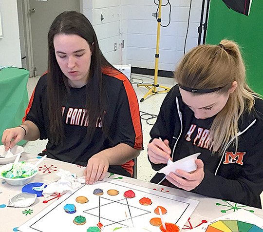 Submitted photo Magnet Cove High School students Olivia Hamby, left, Kristen Teeter and their classmates learned about colors in Regina Efird's Digital Communications I class by creating a color wheel using frosting, food coloring and vanilla wafers.