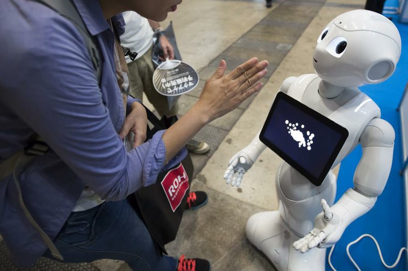 A person looks at a display screen on the front of SoftBank Group Corp.’s Pepper humanoid robot at the Combined Exhibition of Advanced Technologies in Chiba, Japan, in October.