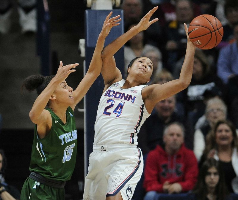 Connecticut forward Napheesa Collier (right) reaches for a rebound over Tulane guard Tene Thompson in the first half of Sunday’s game. Collier had 17 points as the Huskies beat the Green Wave 100-56 to win their 93rd game in a row.