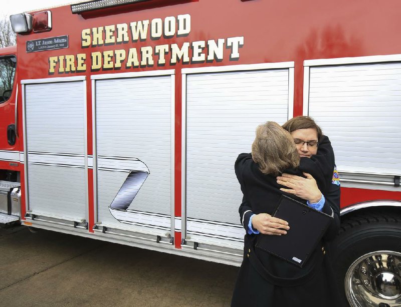 Phylis Stroud (left) hugs Sherwood Fire Department Lt. Jeannie DeMeyere after a ceremony to dedicate a rescue truck in honor of Jason Adams, Stroud’s son and DeMeyere’s fiance. Adams, a Sherwood firefighter, was killed a year ago while responding to a call for the East Pulaski Volunteer Fire Department.