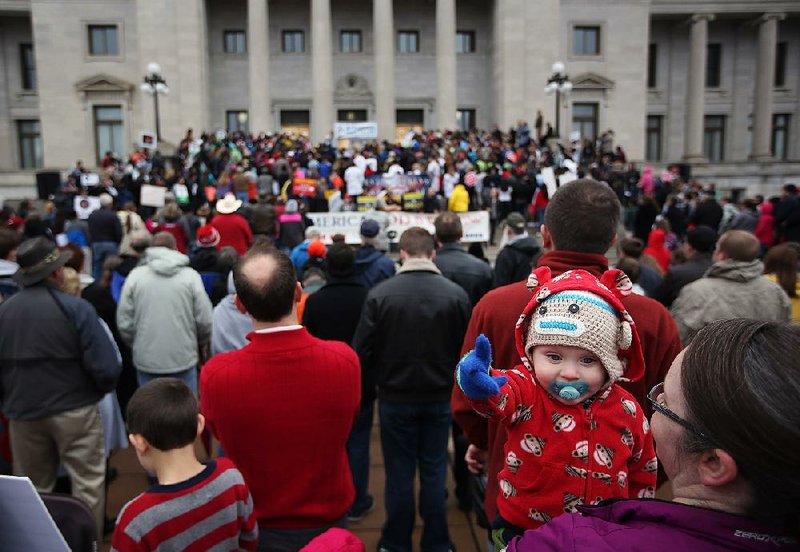 Elliot Timberlake, 1, and his mother, Janet Timberlake of Maumelle, listen to speakers Sunday during the March for Life at the state Capitol in Little Rock.