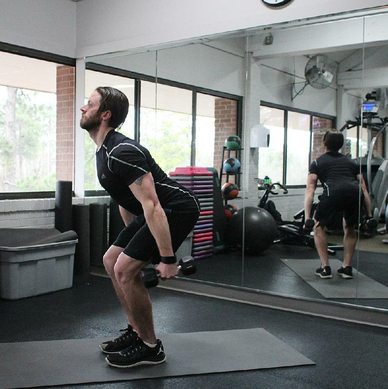 Josh Holt, fitness director at Little Rock Racquet Club, does step 1 of the Skier Swing exercise