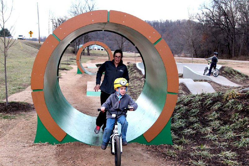 Alexandra Odesskiy of Bentonville chases her son Daniel on his maiden ride on the Bike Park at Slaughter Pen on New Year’s Day in Bentonville.
