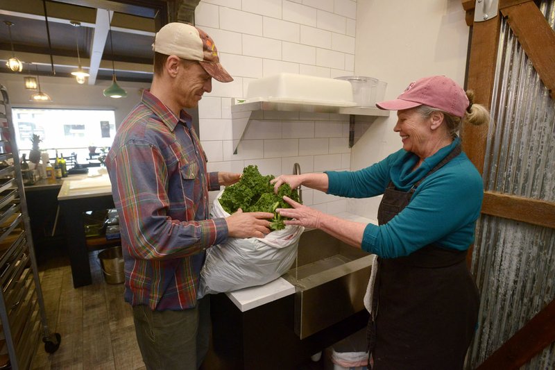 Paul Chapracki from Ozark Alternatives farm brings a delivery of fresh kale to Sheila Reese, owner of Cooking Studio, on Jan. 9 in Downtown Rogers. The business opened Jan. 3 and will offer cooking classes in addition to lunch on Tuesday and Wednesday.