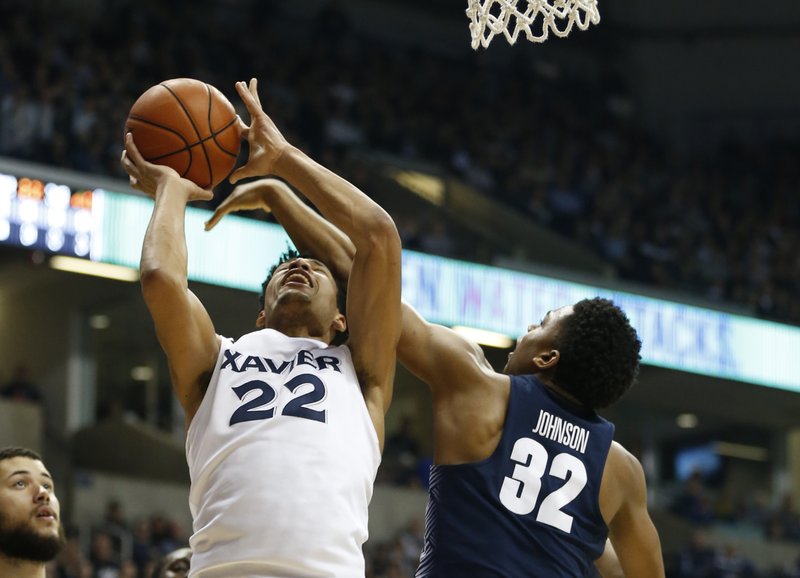 The Associated Press GETTING OFF A SHOT: Xavier forward Kaiser Gates (22) shoots against Georgetown guard Kaleb Johnson (32) during the first half of Sunday's game in Cincinnati. Xavier won 86-75.