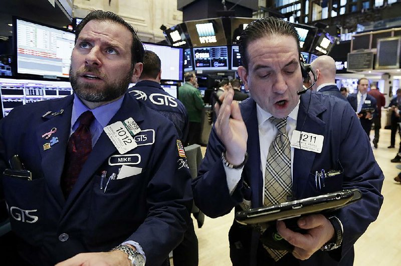 Michael Pistillo (left) and Tommy Kalikas work Monday on the fl oor of the New York Stock Exchange.