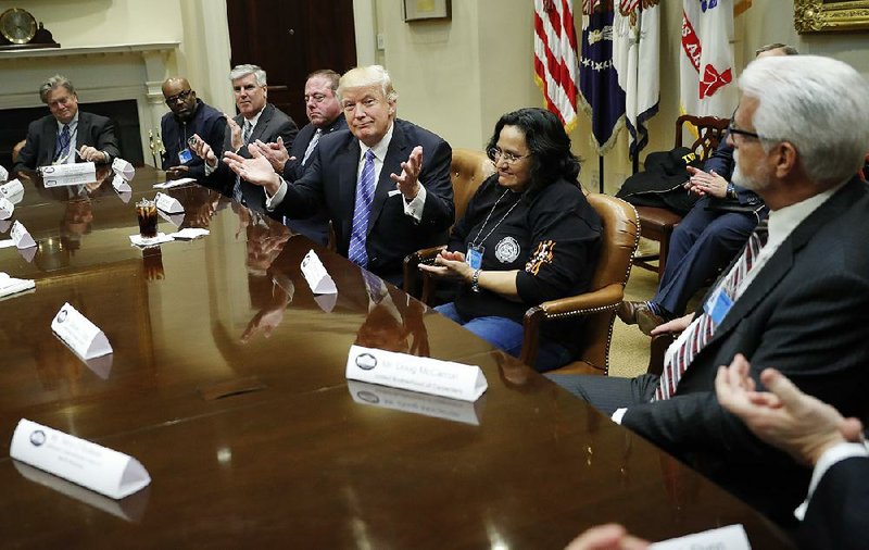 President Donald Trump speaks with business leaders Monday in the Roosevelt Room of the White House.