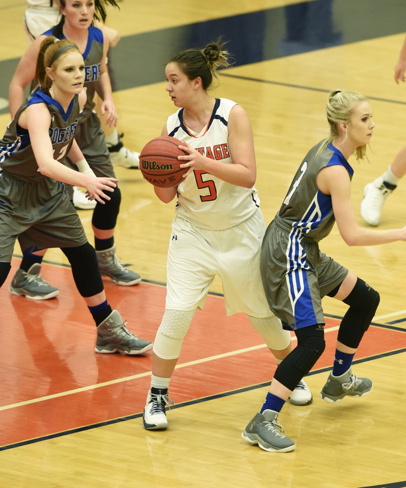 Shelby Thompson (above photo) with Rogers Heritage tries to take the ball to the hoop Tuesday during their game against Rogers High. (Top photo) Thompson is introduced before the game.