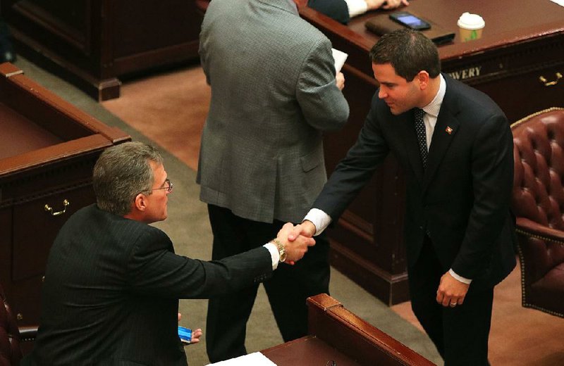 After his bill for a higher earned income tax credit was defeated, Rep. Warwick Sabin (right) shakes hands with Rep. Charlie Collins, who spoke against the measure. 