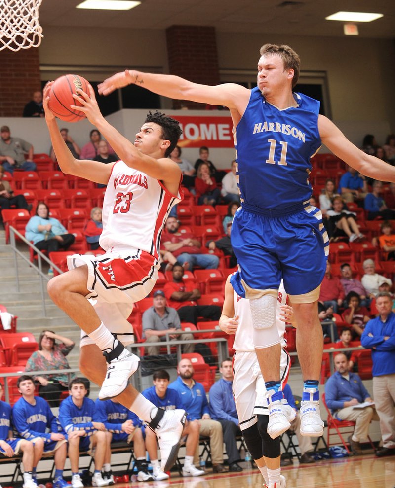 Xavier Staten (23) of Farmington scores in transition ahead of Harrison’s Trevor Atwell on Tuesday at Cardinal Arena in Farmington. Visit nwadg.com/photos for more pictures from the game.