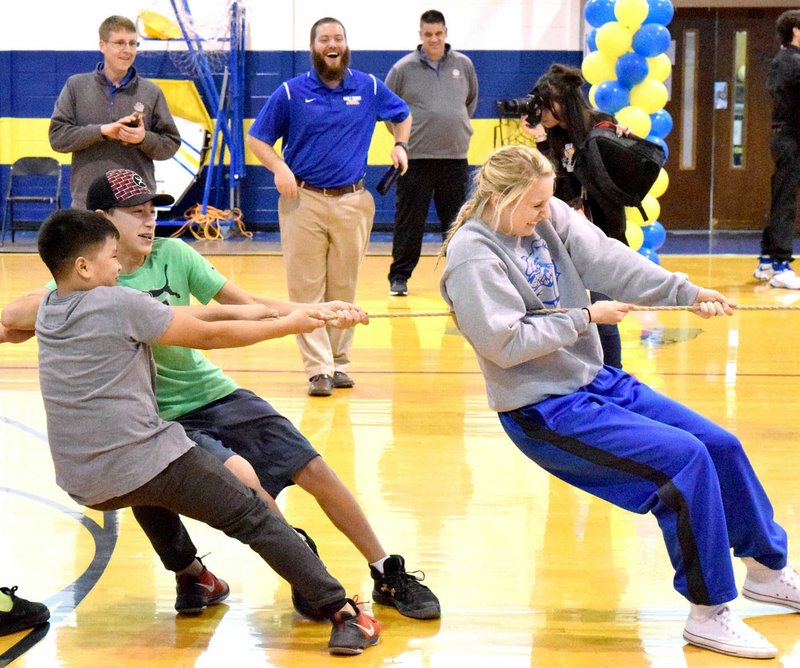 Ashley Riggles, assistant basketball coach for the Lady Bulldogs, helps out the seventh-grade team during the tug of war with the eighth-grade team during the Decatur Colors Day pep rally at Peterson Gym in Decatur on Jan. 20. Despite her efforts, the eighth graders won the contest.