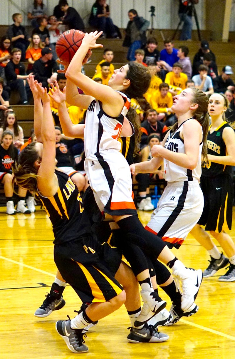 Gravette freshman, Cally Kildow, goes up for a shot against a tough Prairie Grove defense during play between the two teams at Lion Field House in Gravette on Tuesday, Jan. 24, 2017. Kyrstin Branscum is behind Kildow.