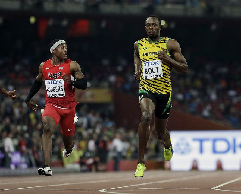 Jamaica's Usain Bolt, right, and United States' Mike Rodgers run in a men's round one heat of the 100m at the World Athletics Championships at Bird's Nest stadium in Beijing, Saturday, Aug. 22, 2015. 