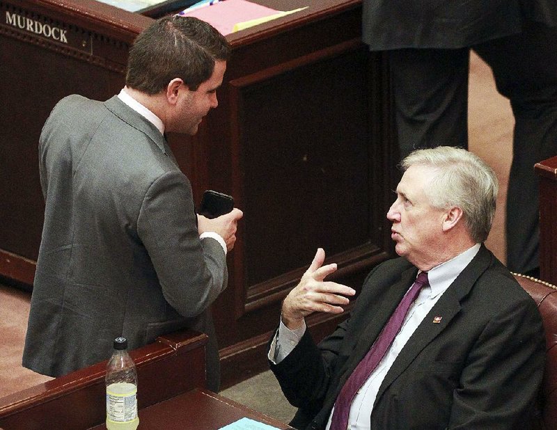 Rep. Warwick Sabin (left) asks Rep. Mark Lowery about his voter-identification bill on the House floor Wednesday. Sabin spoke against the measure.