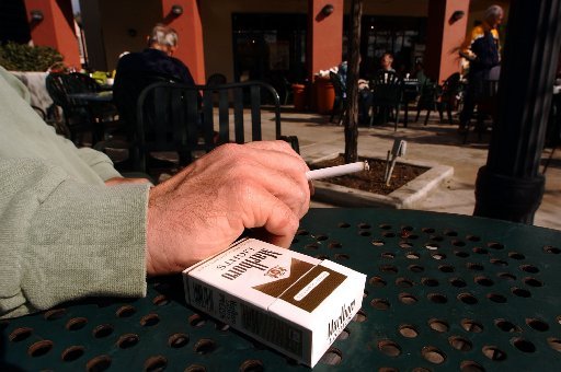 A man smokes a Marlboro Lights brand cigarette while sitting in a plaza in San Diego, California, on Sunday, January 25, 2004/Bloomberg News