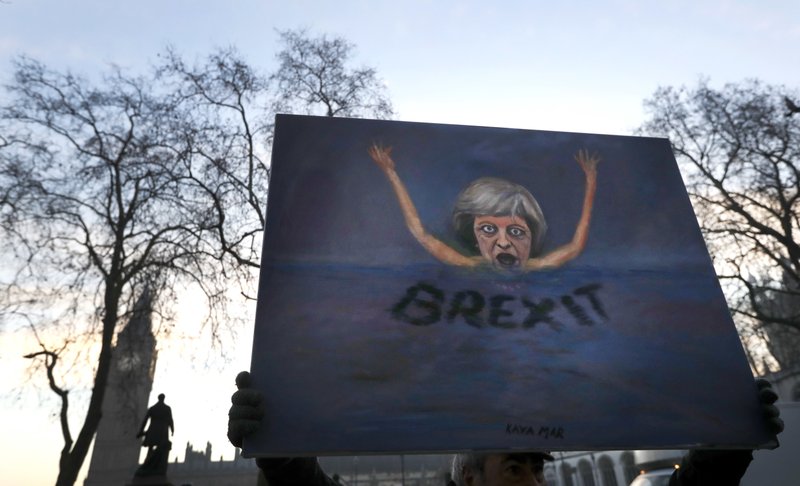 Artist Kaya Mar holds a painting near Parliament in London on Tuesday, Jan. 24, 2017. 