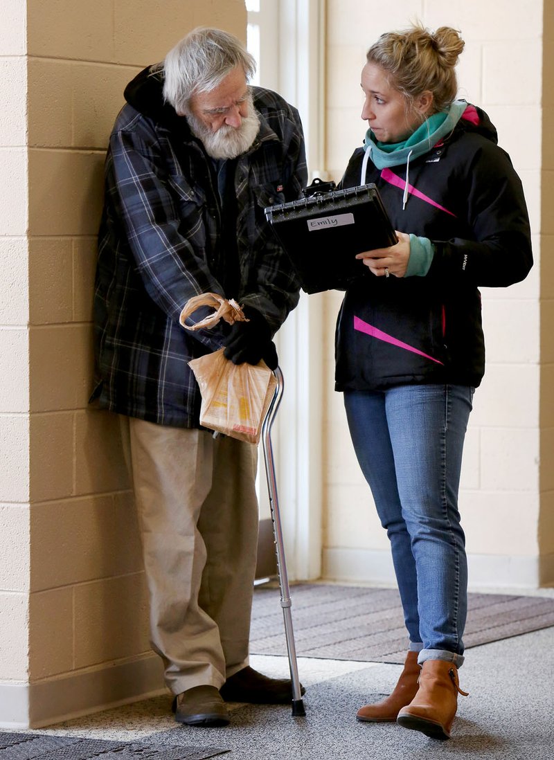 Emily Benson, a volunteer with the Northwest Arkansas’ biennial, 24-hour homeless census, interviews Don McNaughton, homeless, on Thursday in the lobby at Central United Methodist Church in Fayetteville. The survey is being done in both Benton and Washington Counties and was organized and implemented by the Community and Family Institute at the University of Arkansas.