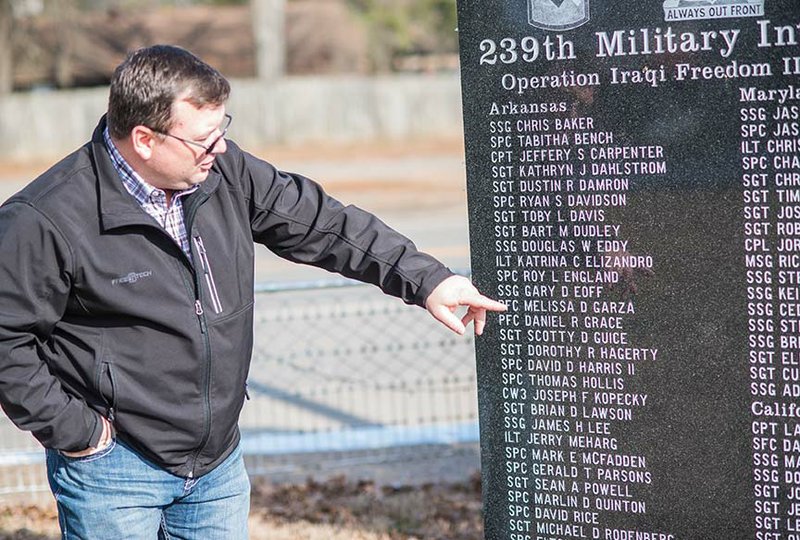 Perry County Judge Toby Davis points out names on a memorial honoring the soldiers of the 239th Military Intelligence Co. that served in Operation Iraq Freedom II from 2003-2005. Davis served as an Arkansas National Guardsman in the unit, along with others from several states. The memorial was first located at the National Guard Armory in Perryville, but when the armory was closed a few years ago, Davis asked that the memorial be moved to the Perry County Courthouse.