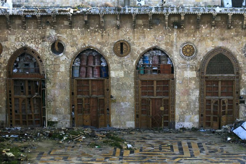 The doors at the main entrance of the Great Mosque of Aleppo, in the Old City of Aleppo, Syria, reveal a glimpse of the damage done to the centuries-old structure.