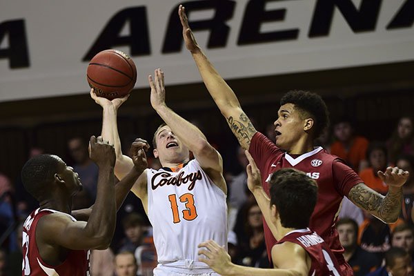 Oklahoma State's Phil Forte drives into three Arkansas defenders during an NCAA college basketball game in Stillwater, Okla., Saturday Jan. 28, 2017. (Tyler Drabek/Tulsa World via AP)

