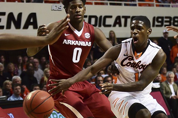 Oklahoma State's Jawun Evans throws a pass past Arkansas' Jaylen Barford during an NCAA college basketball game in Stillwater, Okla., Saturday Jan. 28, 2017. (Tyler Drabek/Tulsa World via AP)

