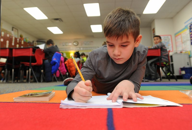 NWA Democrat-Gazette/ANDY SHUPE Colby Pianalto, 9, a third-grader at Shaw Elementary School in Springdale, writes in his journal Thursday after a lesson about a book he and other students are reading. Students are participating in a new curriculum designed around a reading workshop, where a teacher gives a short lesson, releases students to work and then ends with a short wrap up.