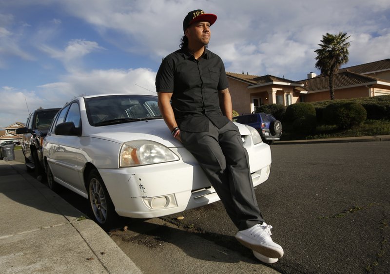 In this photo taken Thursday, Jan. 26, 2017, Aaron Cutchon, 35, poses next to his car in Cordelia, Calif. Cutchon had his driver's license suspended after he was laid off from his job and was unable to keep up the payments on the nearly $2,000 in added fees and fines. State Sen. Robert Hertzberg, D-Van Nuys , has introduced a bill to ban the practice of suspending person's driver's licenses because they couldn't afford a traffic ticket. (AP Photo/Rich Pedroncelli)