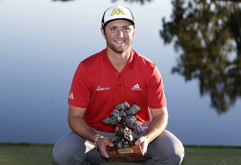 Jon Rahm, of Spain, holds the trophy after winning the Farmers Insurance Open golf tournament Sunday, Jan. 29, 2017, at Torrey Pines Golf Course in San Diego. 